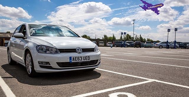 Car parked outside an airport with Holiday extras logo on a plane